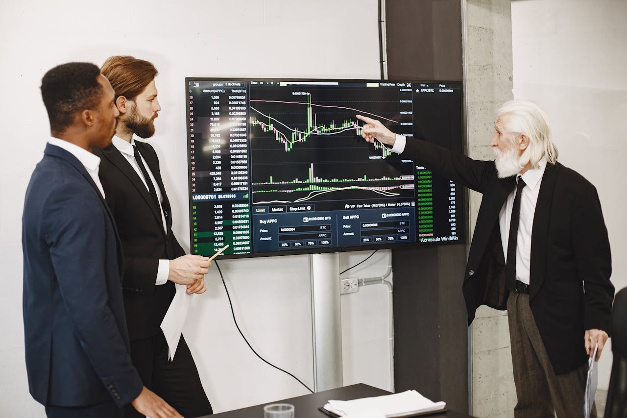 services-01 A diverse business team in a meeting analyzing stock market data on a screen.